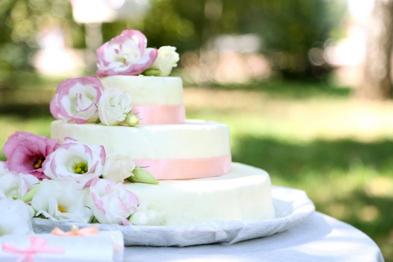 Bílo-růžový patrový svatební dort zdobený květy