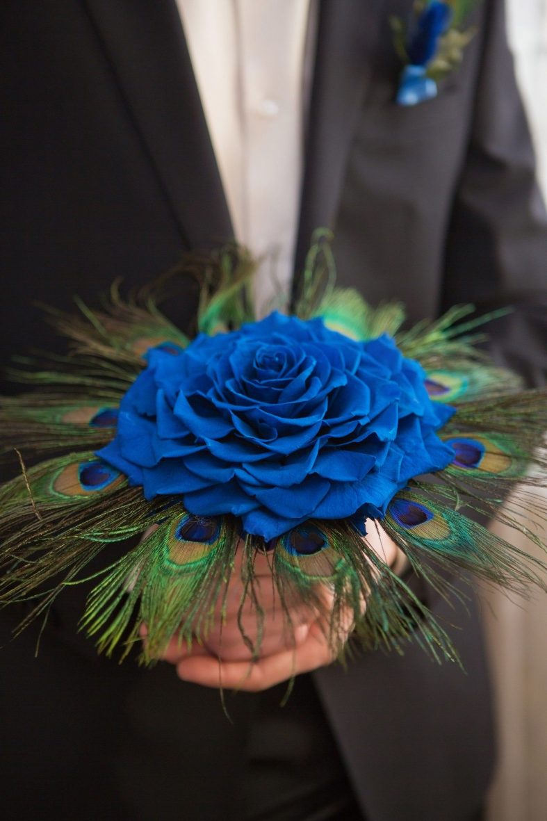 Svatební kytice s velkým květem modré růže a pavím perem